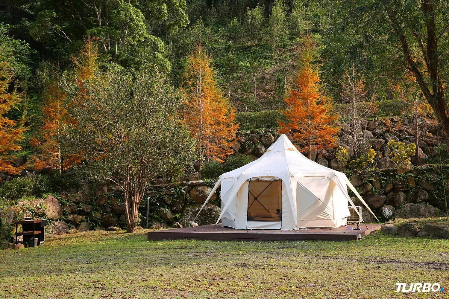 Lotus tent on a timber deck among autumn trees